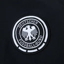 Corta vento retrô Alemanha 2024 2025, jaqueta leve com escudo bordado, agasalho da seleção alemã, modelo clássico preto e branco, corta vento futebol estilo retrô, jaqueta Alemanha para frio e vento

